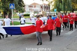 Юные спортсмены приняли участие в пробеге неся в руках  большое полотнище российского флага и воздушные шары